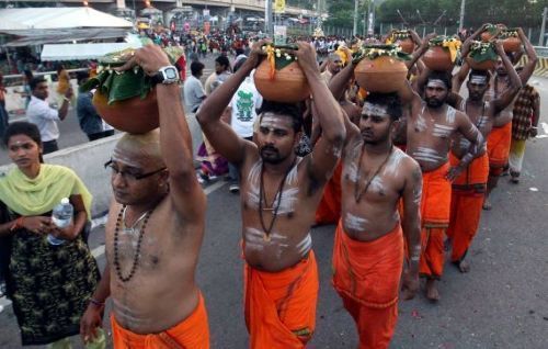 Devotees carry milk pots during the Thaipusam procession at Batu Caves