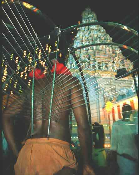 A devotee preparing Arigandi kavadi, the topmost structure is yet to be assembled
