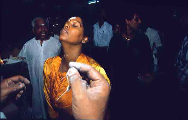 A devotee in a state of trance as she prepares herself to be pierced on her forehead